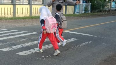 Wujud Polisi Humanis, Brigadir Wawan Satria Atur Lalu Lintas Saat Anak Sekolah di Desa Goa