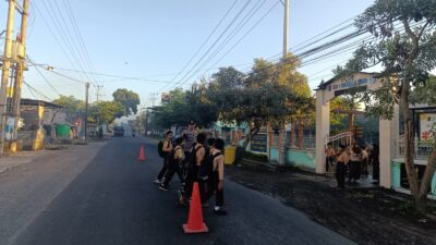 Bhabinkamtibmas Desa Jantuk Laksanakan Rawan Pagi di Depan SMP 1 Sukamulia untuk Kelancaran Arus Lalu Lintas